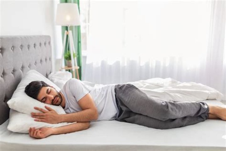 Billie lying on a bed (headshot) with her hands shown, every finger filled with rings. Her Net Worth is helping her.